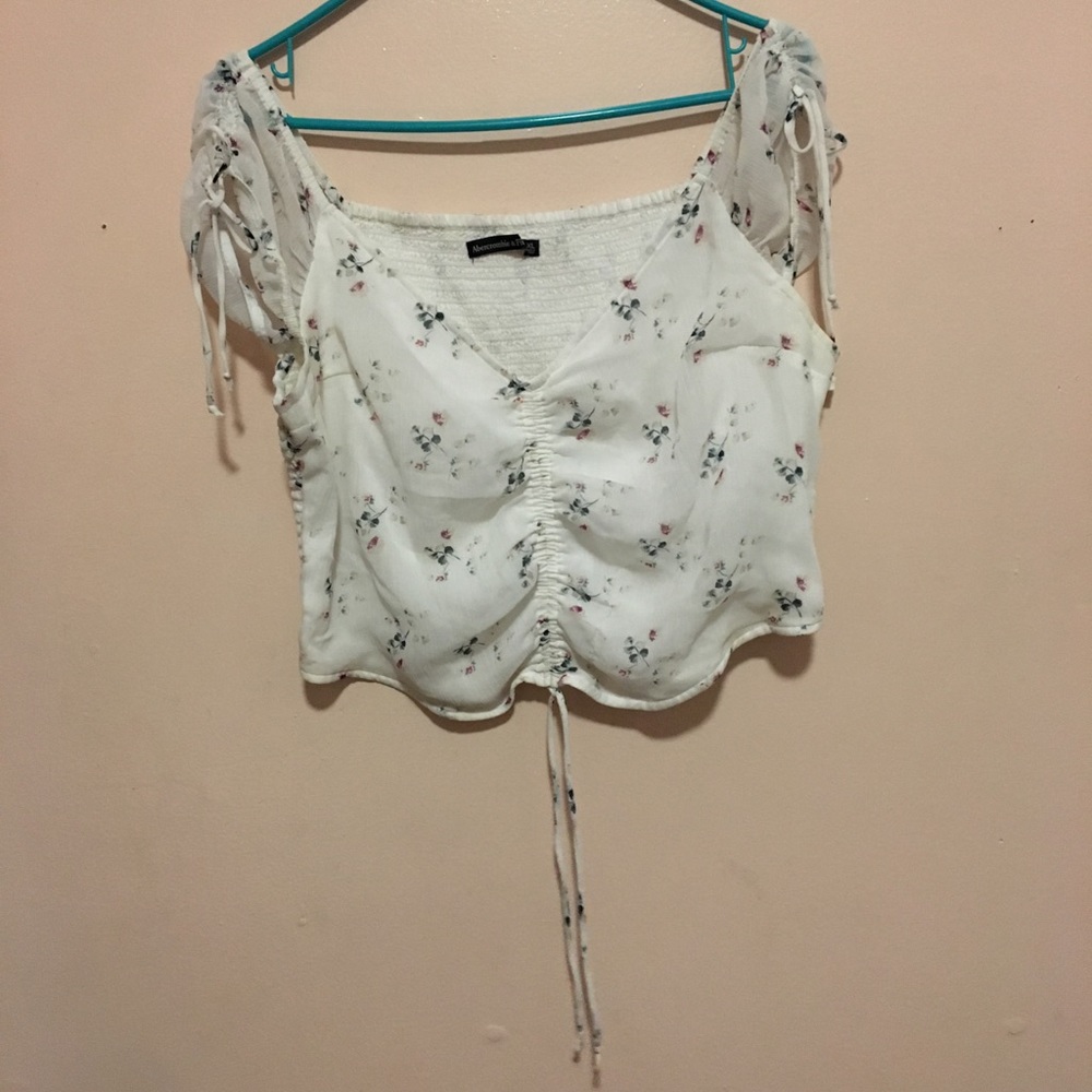 This is a white crop top with small leaf design